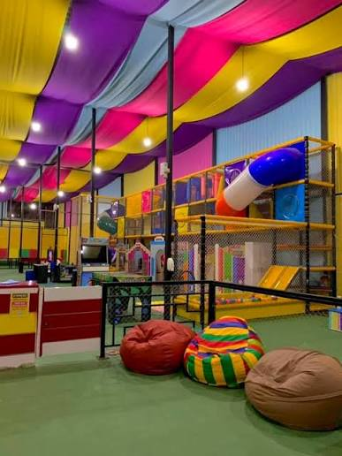 Brinquedoteca Juju Kids com tendas coloridas, brinquedos e pufes